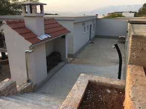 A rooftop with a red-tiled roof, a concrete floor, and a small garden area with a planter. - House Kupina (Gdinj)