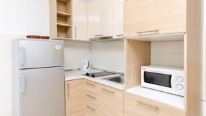 Une cuisine moderne équipée d’un réfrigérateur, d’un four à micro-ondes, d’une bouilloire et d’un évier.