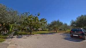 A gravel driveway leading to a parked car. - Apartment Mediteraneo (Fazana)