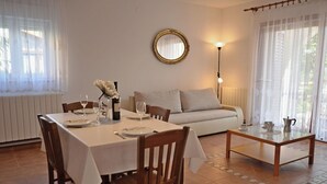 A dining area with a table set for two, a sofa, and a coffee table. - Apartment Mediteraneo (Fazana)