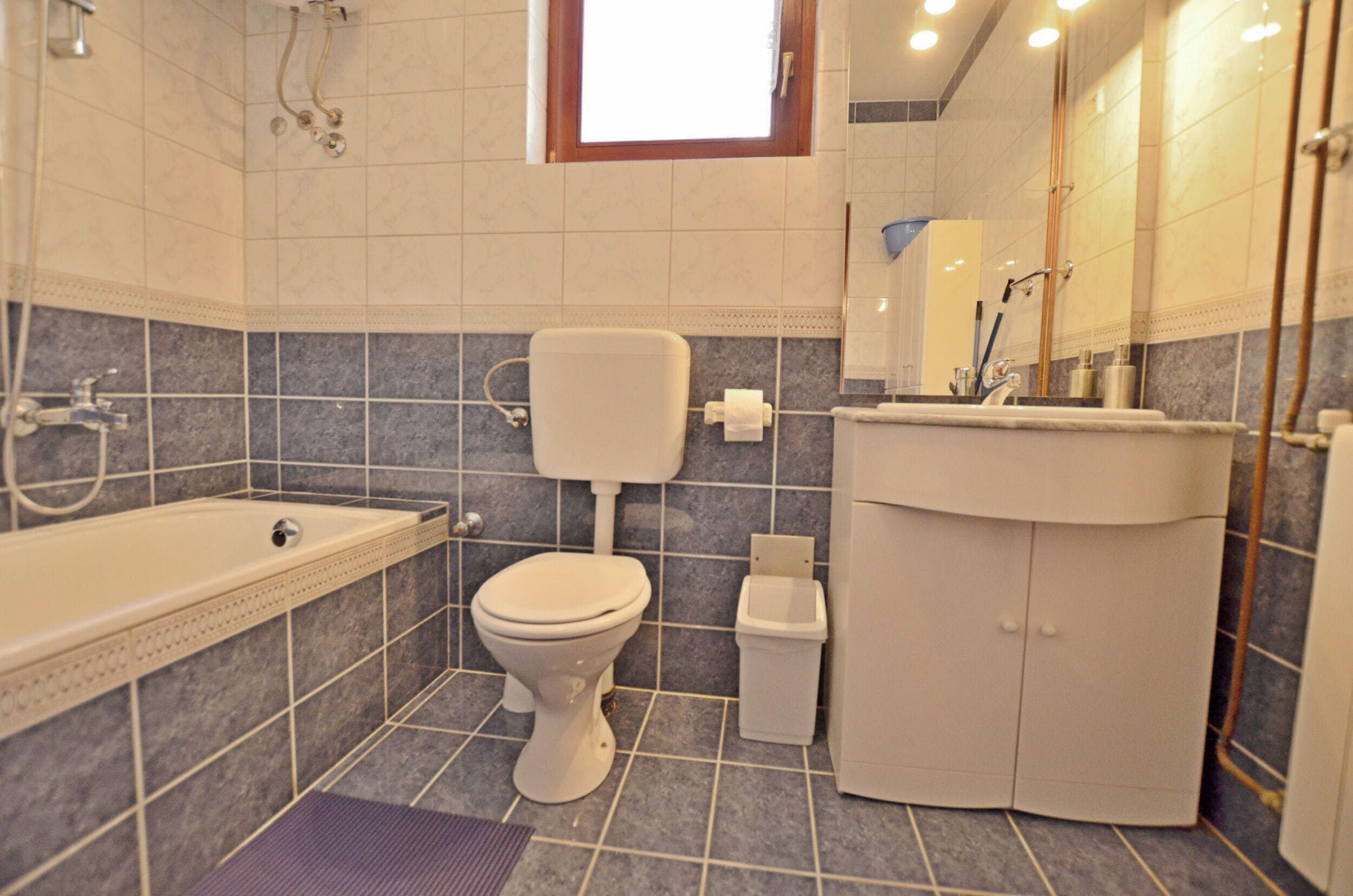 Een badkamer met toilet, wastafel en bad.