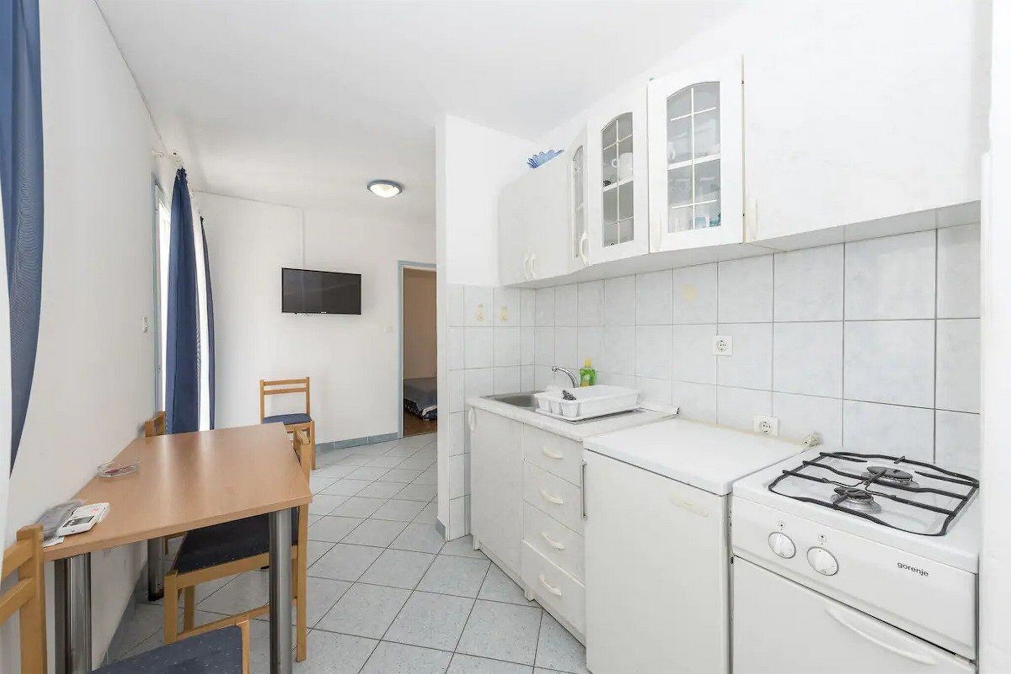 A compact kitchen with white cabinets, a gas stove, and a small countertop.