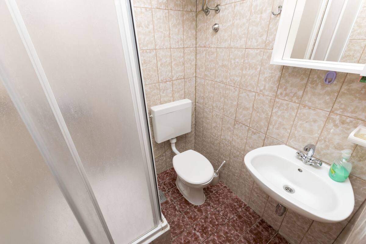 A bathroom with a toilet, sink, and shower.