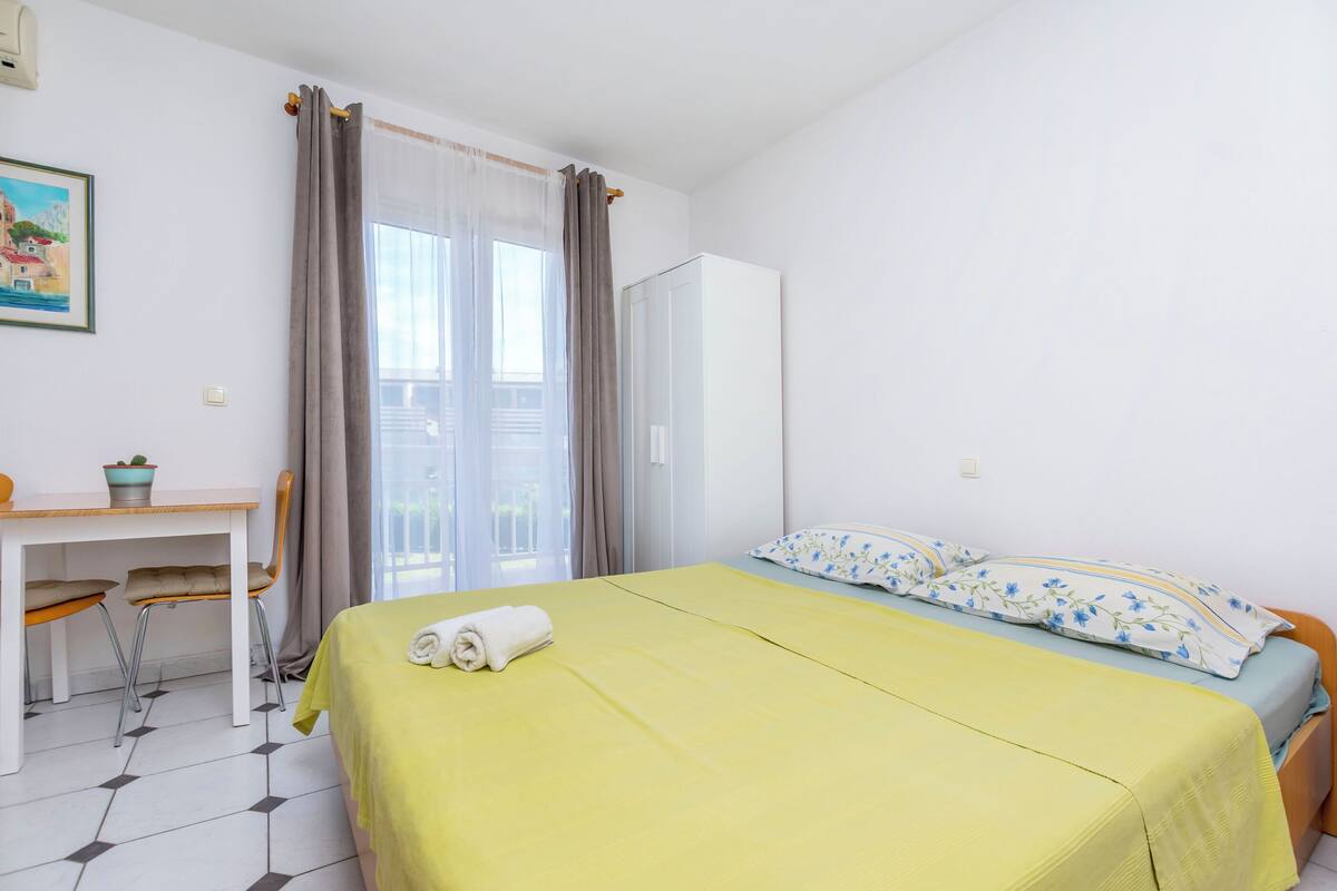 A room with a bed, a desk, and a chair.