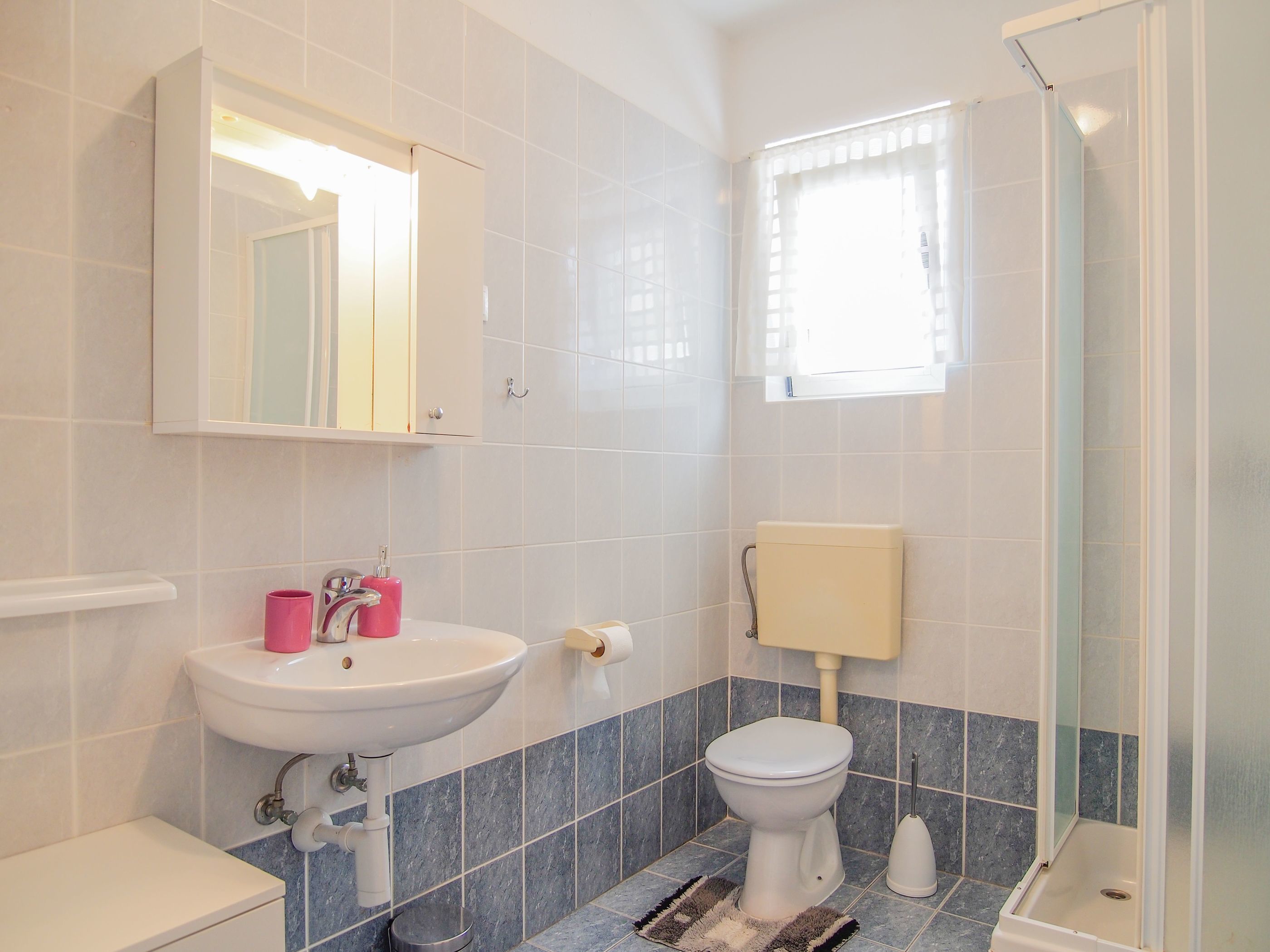 A bathroom with a sink, toilet, and shower.