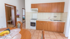 Una cocina con armarios de madera, una estufa a gas, un horno y un fregadero.