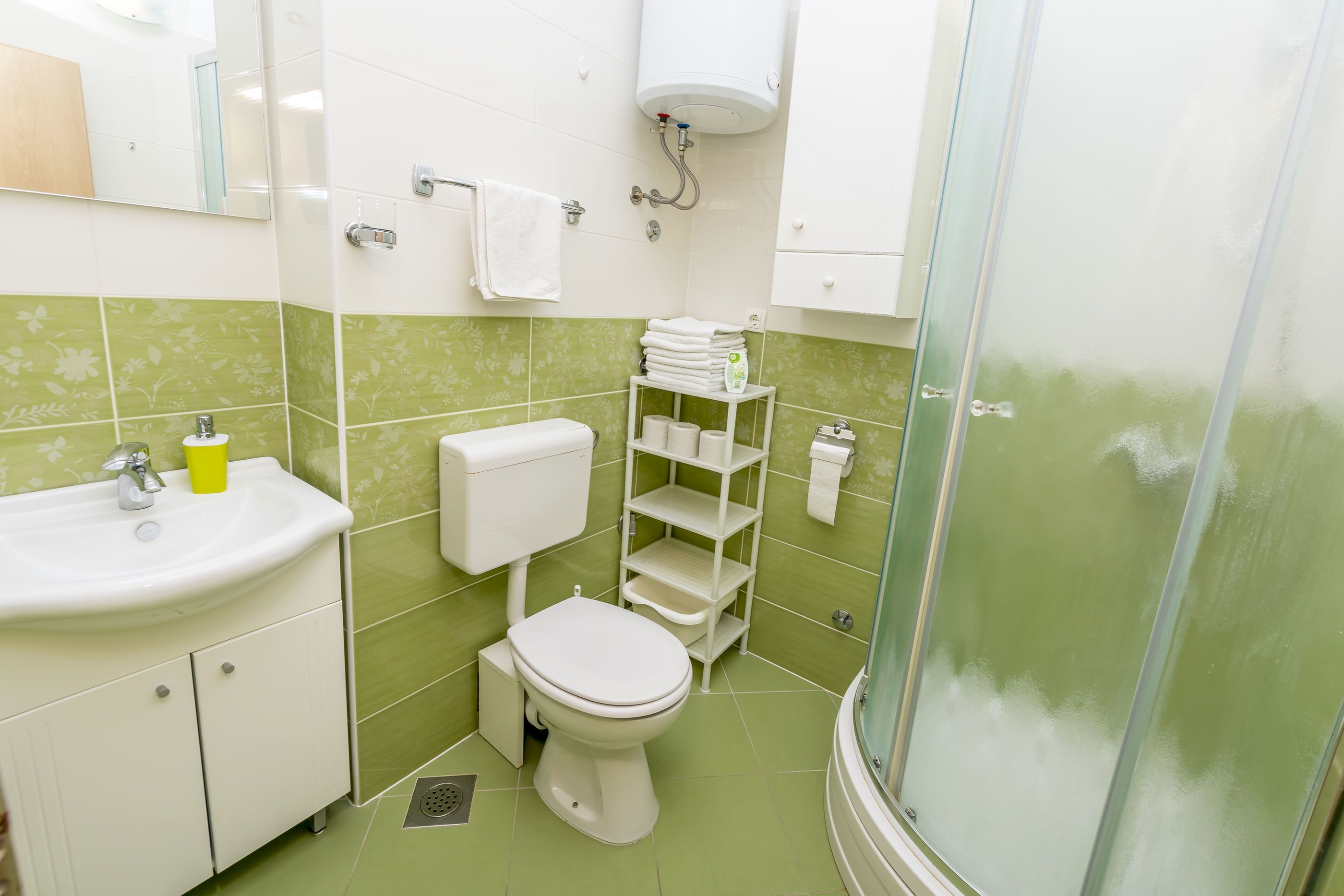 A bathroom with a toilet, sink, and shower.