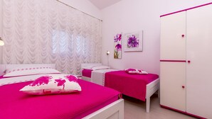 A bedroom with two beds, white curtains, a wardrobe, and wall art. - Apartment Bakovic (Rogoznica)