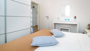 A hotel room with a bed, a bedside table, a mirror, and a wardrobe. - House Goran (Kolan)