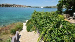 Una escalera conduce a una terraza con vista a un lago y a un pueblo distante.