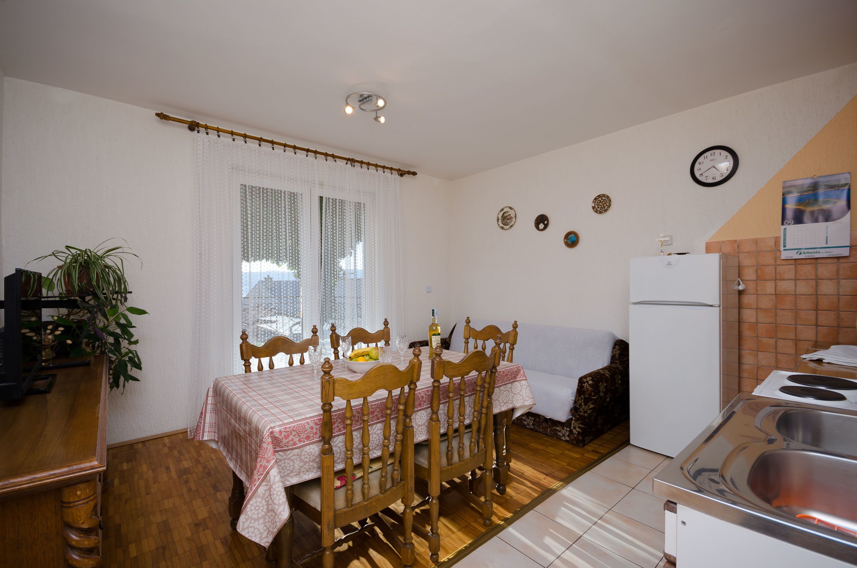 Une cuisine de taille réduite comprenant une table à manger, des chaises, un réfrigérateur et un évier.