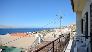 A balcony with a view of the sea and neighboring buildings. - Apartment Milan (Senj)