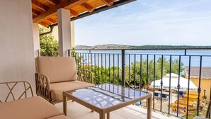 Ein Balkon mit Blick auf einen See und ein Restaurant im Hintergrund.
