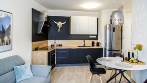 Una cocina moderna con una isla central, una mesa de comedor y un sofá.