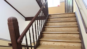 Una escalera de madera con barandales oscuros que conduce a una plataforma.