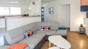 A modern living room with a grey sectional sofa, a white coffee table, and a teal throw pillow. - Cozy home in Ginestas with WiFi (Ginestas)