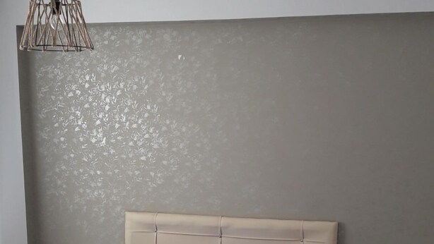 A bedroom with a bed, two bedside tables, a hanging light fixture, and a textured wall. - Celebi Apart Hotel (Izmir)