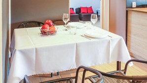 A dining table set with plates, glasses, and a fruit basket. - Nice apartment in Borcz with kitchen (Borcz)