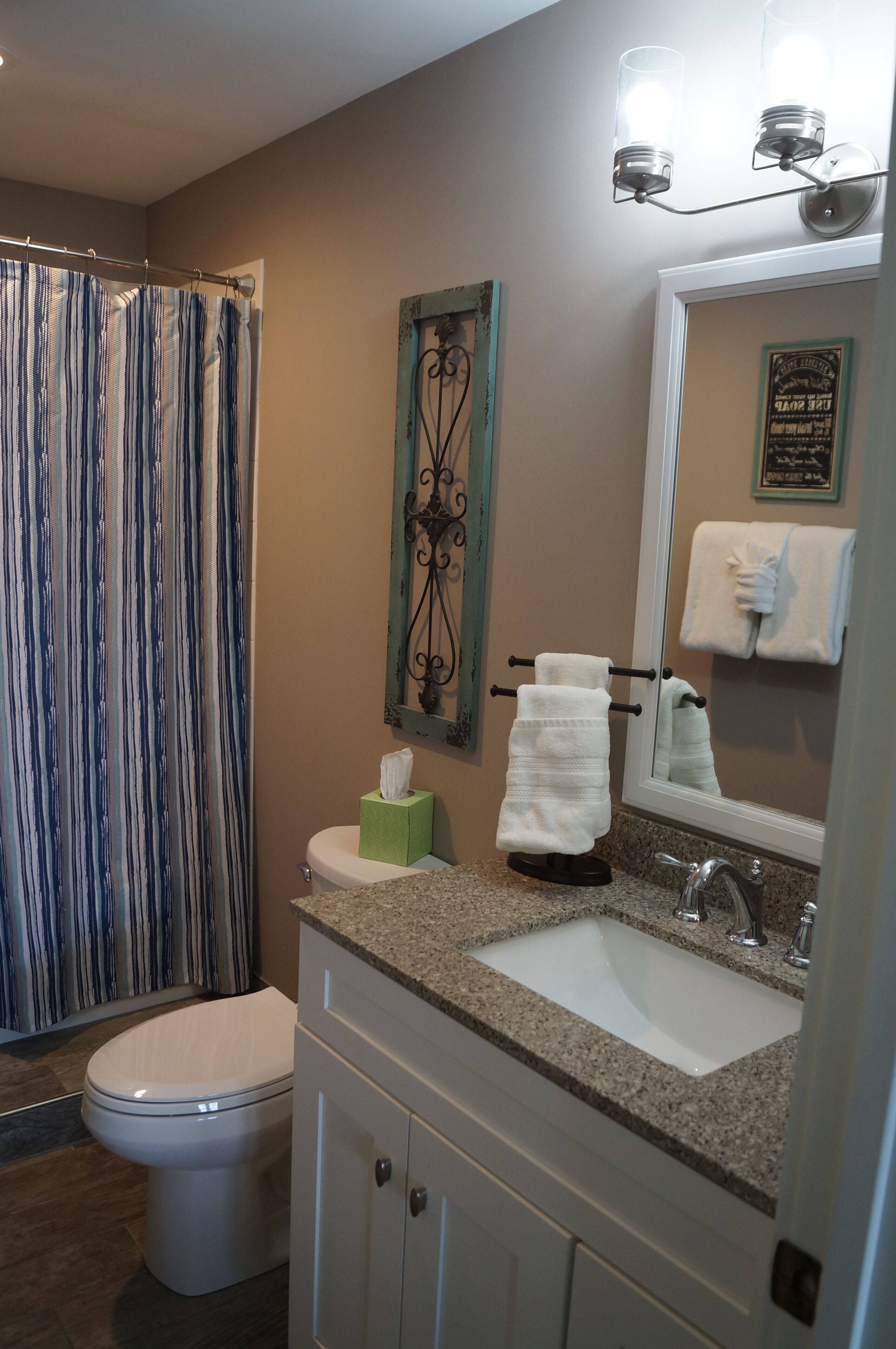A bathroom with a toilet, sink, and shower curtain.