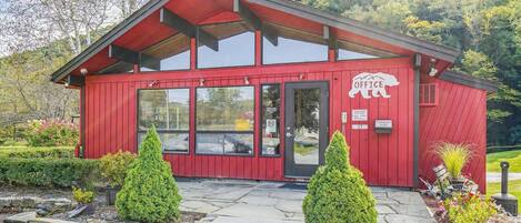 A red office building with a sloped roof, large windows, and a sign that reads 'OFFICE'.