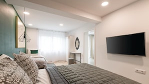 A modern bedroom with a large bed, a TV mounted on the wall, and a desk with a chair. - Awesome apartment in Fazana with WiFi (Fazana)