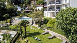 Un immeuble à plusieurs étages doté de balcons, d’une piscine et d’un jardin bien entretenu.