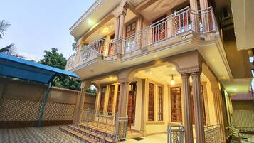 A two-story building with a balcony, columns, and a patterned floor.
