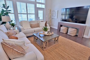 Ein Wohnzimmer mit einer Couch, einem Couchtisch und einem Flachbildfernseher.