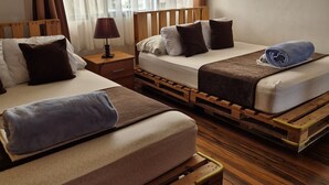 A room with two beds, a nightstand, a lamp, and a view of the outdoors. - Eco Stay CR (San José)