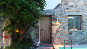 A stone building with a wooden door, a pool with metal ladders, and decorative lights. - Muazzo Creta Stone House, Nature Escape with Pool (Rethymno)