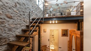 A staircase with a stone wall, a wooden chair, and a wooden cabinet. - Muazzo Creta Stone House, Nature Escape with Pool (Rethymno)
