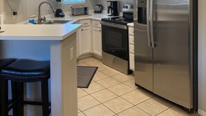 A modern kitchen with white cabinetry, a stainless steel refrigerator, a microwave, and an oven. - Relax Poolside in your private, Clean, Beautiful, Quiet Vacation Condo (Phoenix)