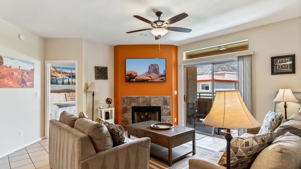 A living room with a fireplace, sofas, a coffee table, and a ceiling fan. - Relax Poolside in your private, Clean, Beautiful, Quiet Vacation Condo (Phoenix)