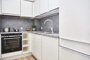 Een koelkast, een oven, een kookplaat, een vaatwasser