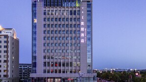 A tall hotel building with multiple floors and a prominent entrance. - Mercure Ordos Downtown (Ordos)