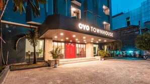 A modern building with a red entrance and a sign that reads "OYO TOWNHOUSE". - Super OYO Townhouse 2 Hotel Gunung Sahari (Jakarta)
