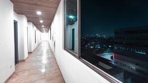 A corridor with a view of a cityscape at night. - Super OYO Townhouse 2 Hotel Gunung Sahari (Jakarta)