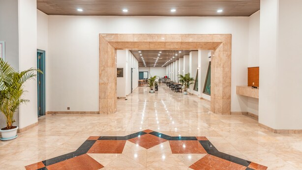 A spacious lobby with a polished marble floor, a central seating area, and a wooden ceiling. - Super OYO Townhouse 2 Hotel Gunung Sahari (Jakarta)