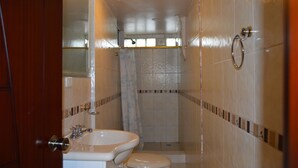 Un baño con lavamanos, inodoro y ducha.