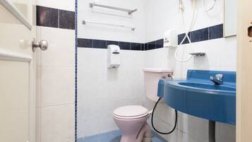 Un baño con inodoro, lavabo y ducha.