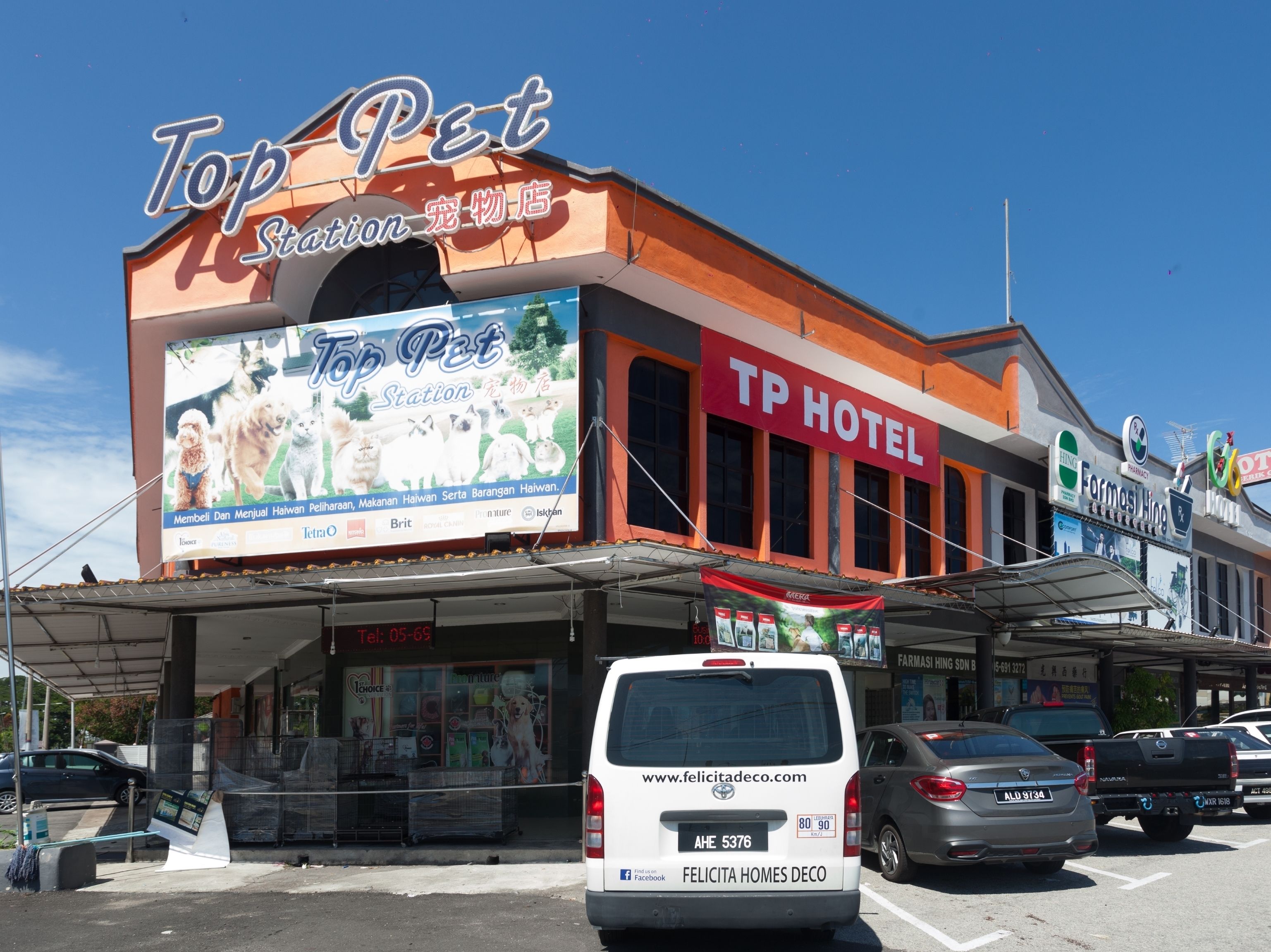 Ein Gebäude mit einem Schild 'Top Pet Station' und einem Schild 'TP Hotel'.
