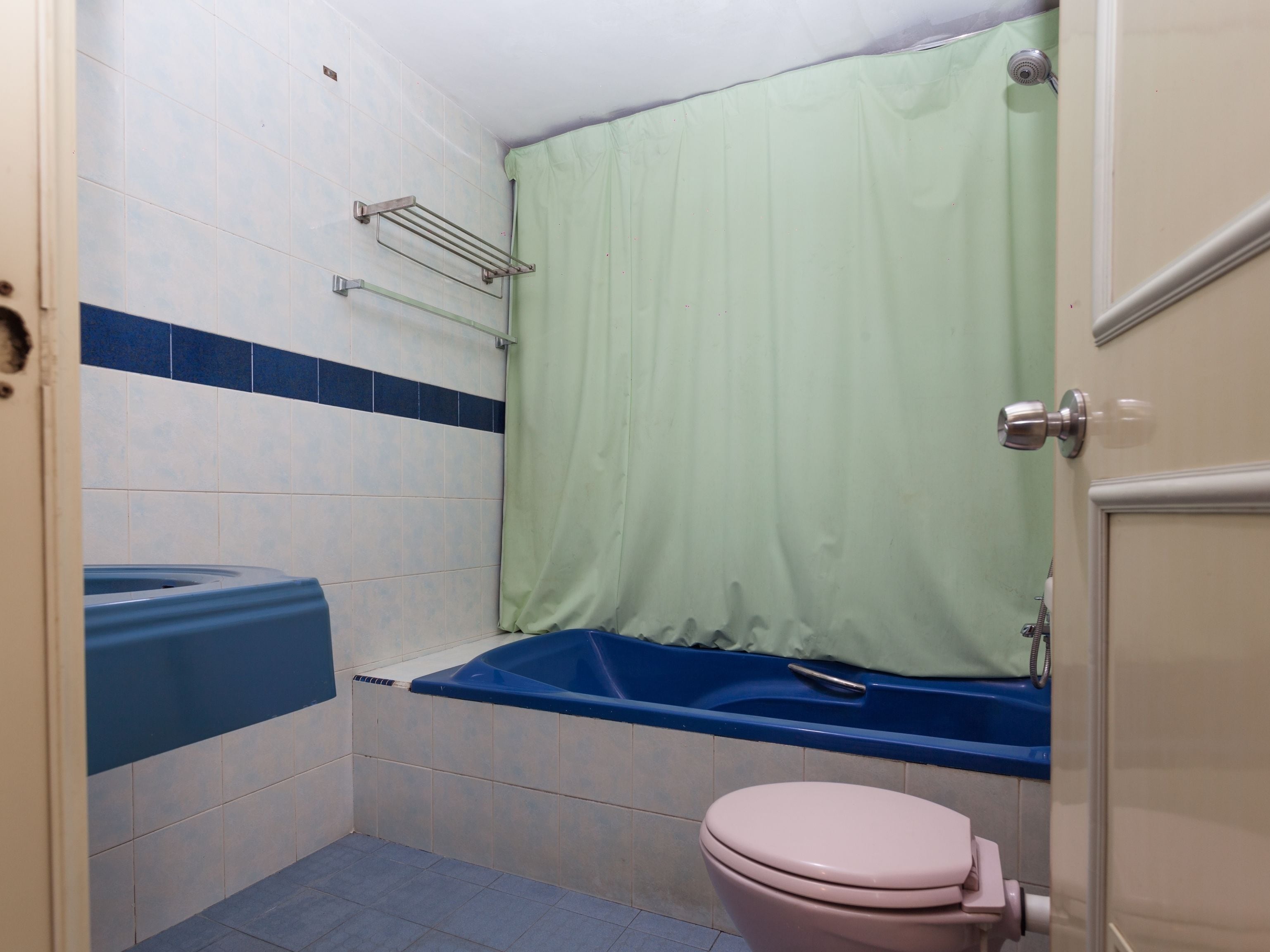 Een badkamer met bad, toilet en douchegordijn.