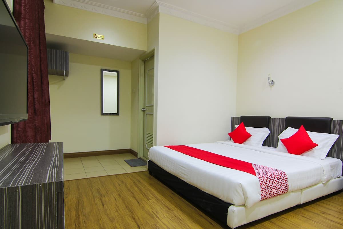 Una habitación de hotel con una cama grande, un escritorio y un televisor.