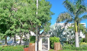 outdoor space with lush greenery and a gated entrance.
