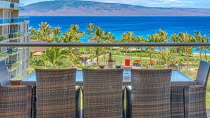 A balcony with wicker chairs overlooking a beach and ocean. - Maui Resort Rentals: Honua Kai Konea 625 - 6th Floor 3BR w/ Ocean Views from Every Room! (Lahaina)