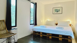 A room with a bed, a chair, and a window. - Pig Dive Hostel (Moalboal)