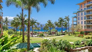 Un resort con piscina, palmeras y vistas al océano.