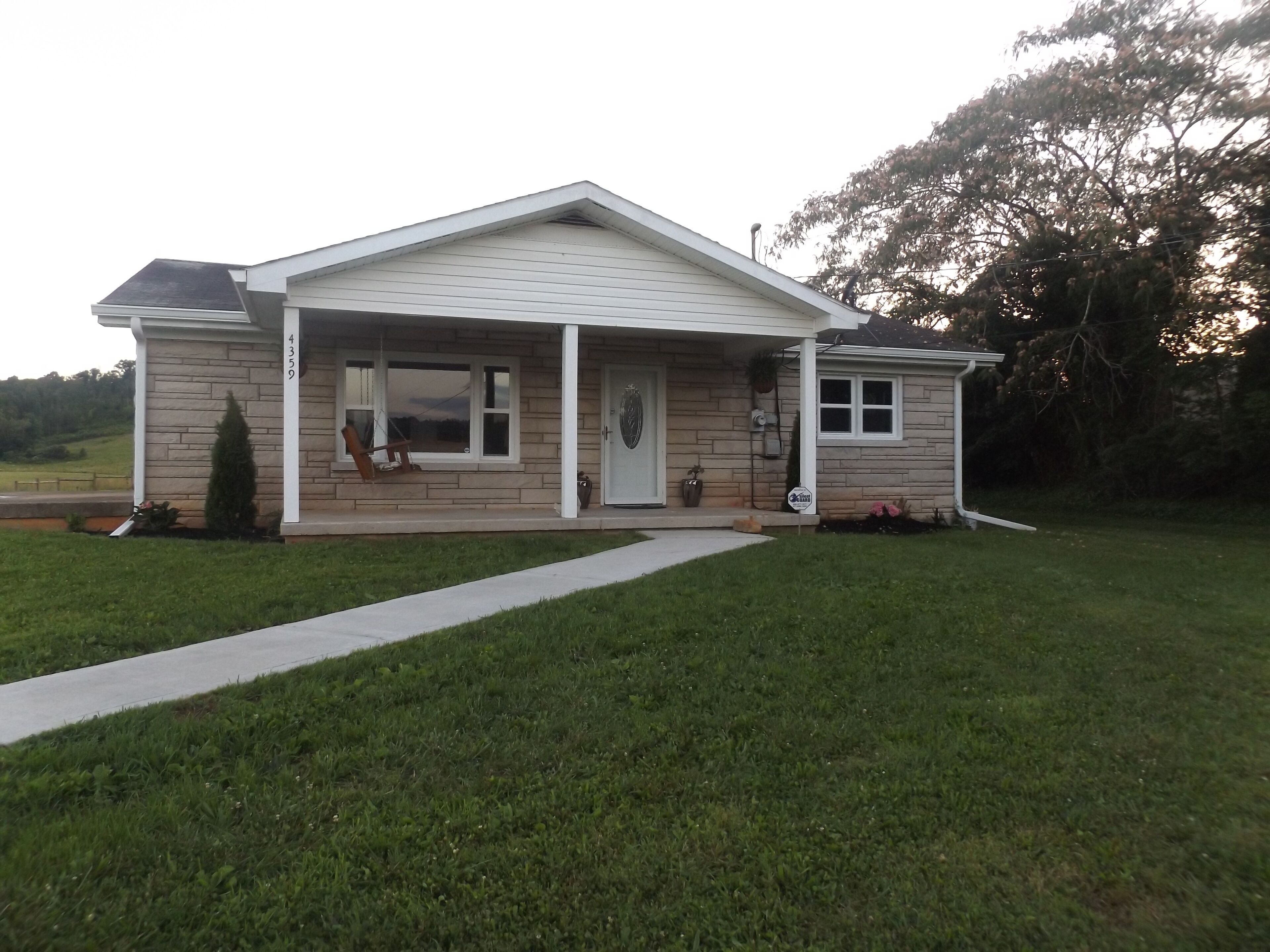 A single-story house with a covered porch, a front door, and a small front yard.