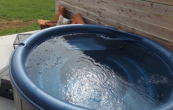 A hot tub with water, a wooden deck, and a chair. - ROMANTIC HOT TUB, FIRE PLACE, FENCED YARD, FIRE PIT, 100 meg WIFI, CUMBERLAND (Somerset)