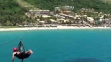 A coastal view with a beach and a building complex in the background.